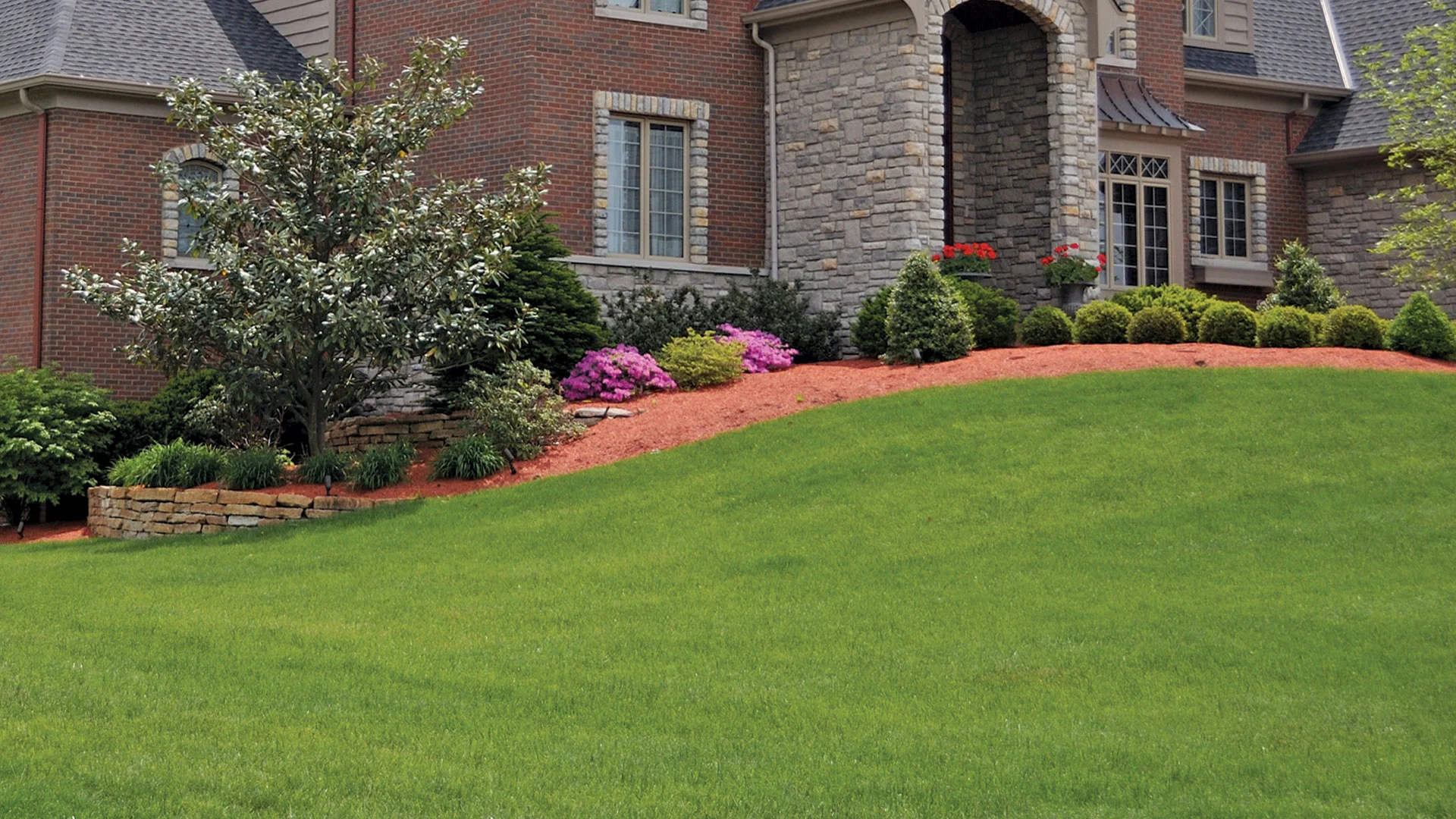 Landscape worker in Ada, MI clearing landscape bed.